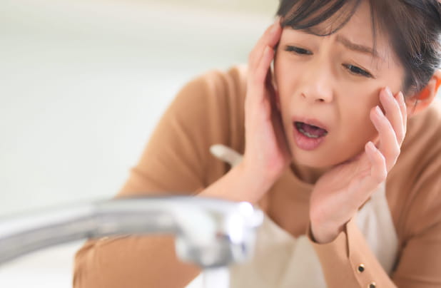 主婦が水道トラブルで困っている様子
