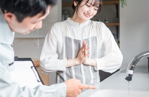 水道業者の人が女性に説明している様子